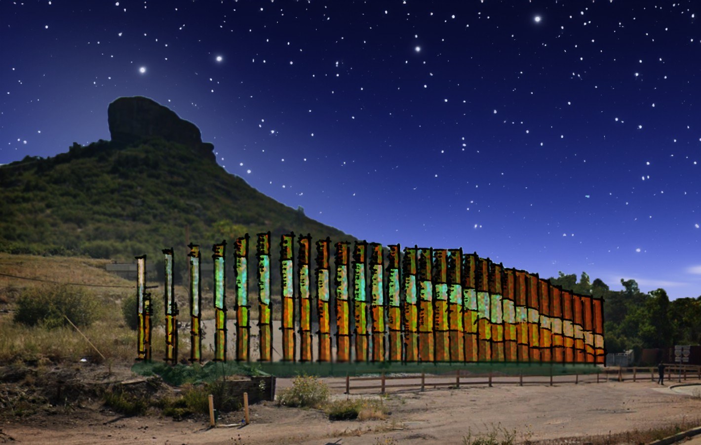 The sculpture lit at night below the Castle Rock